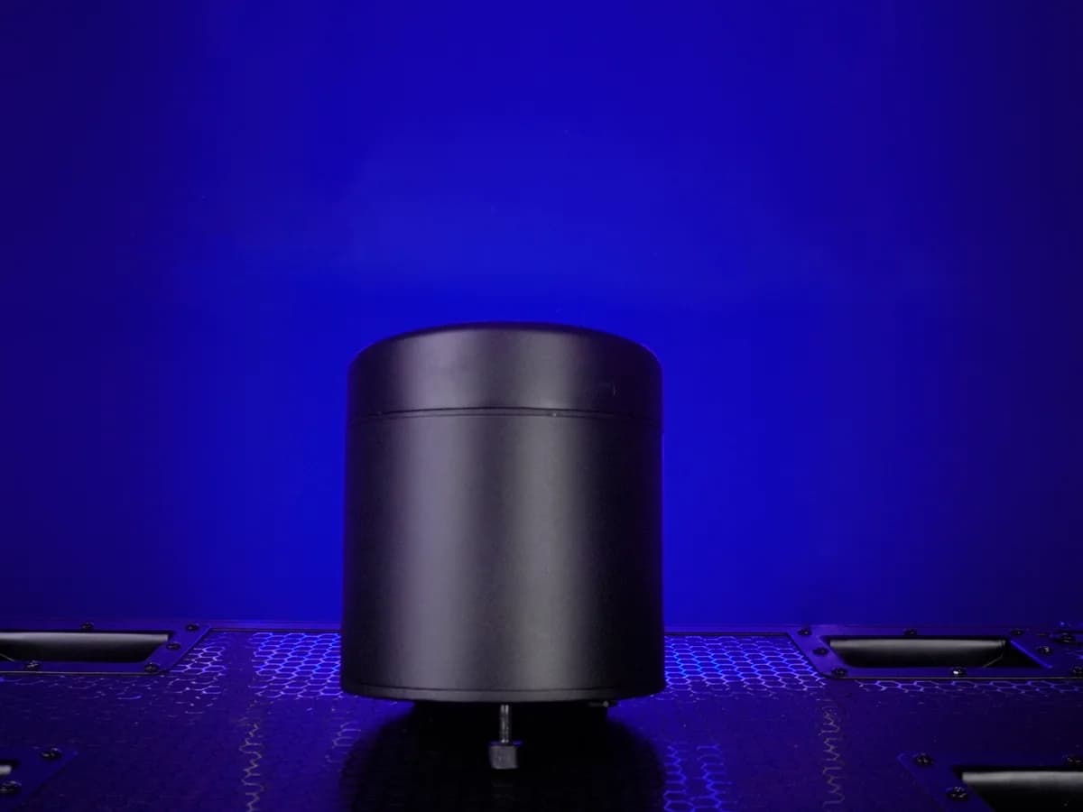 Real LumiUp Aqua P6 battery powered uplight standing upright on a flat equipment case