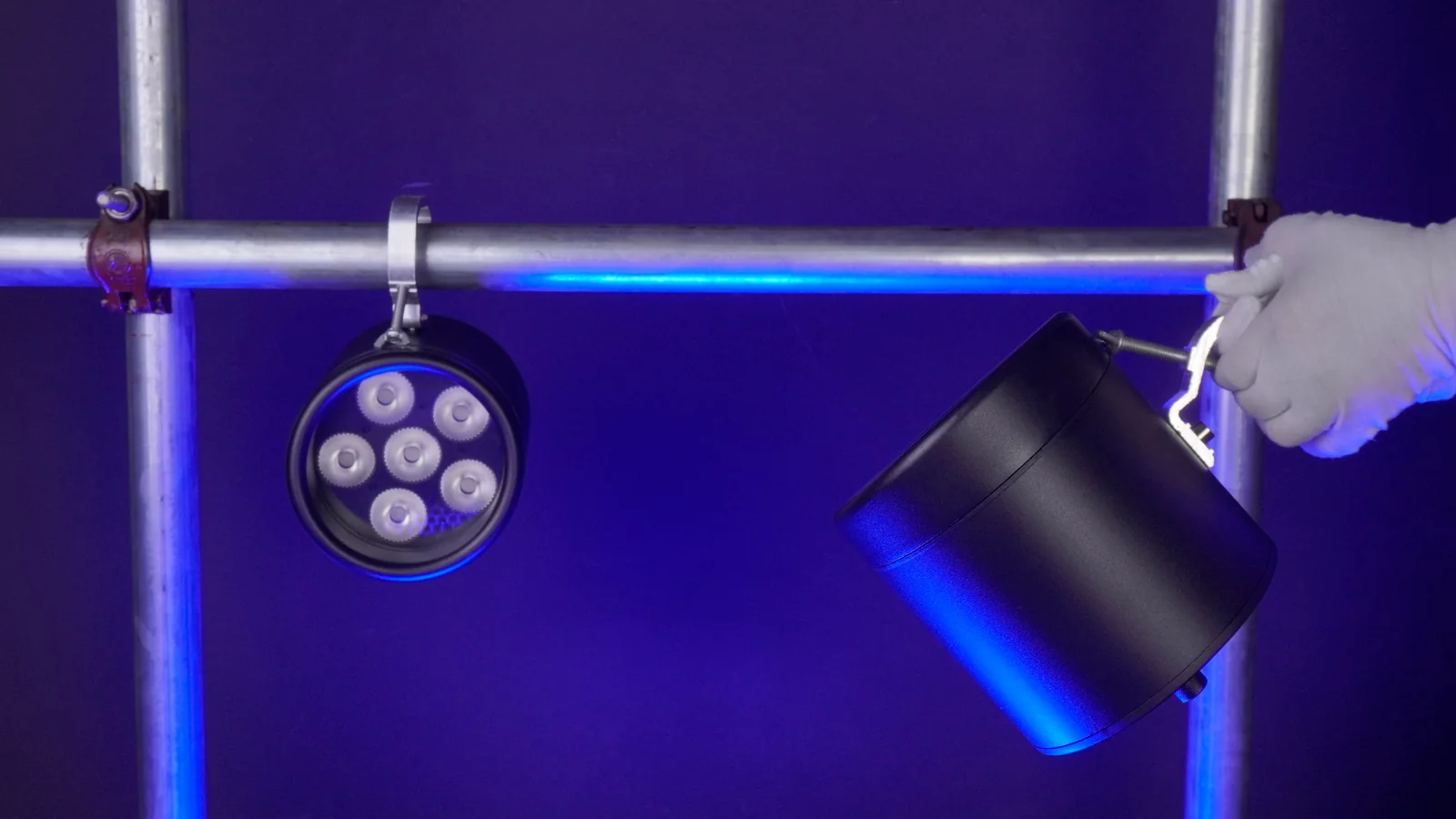 A LumiUp Aqua P6 hanging from a lighting bar while another unit is positioned by an installer