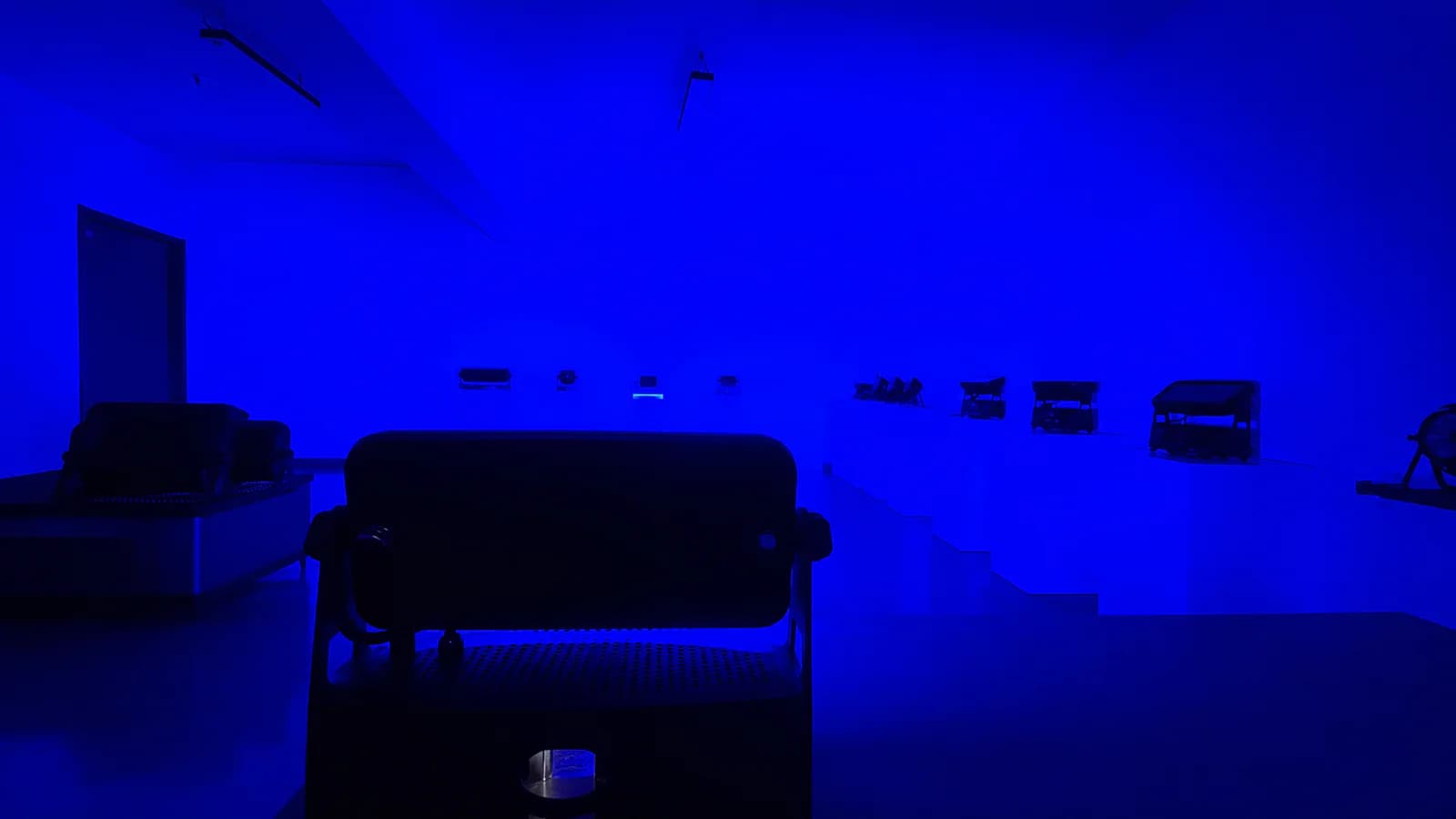 Blue-lit room used for a visual comparison of output from multiple stage lights
