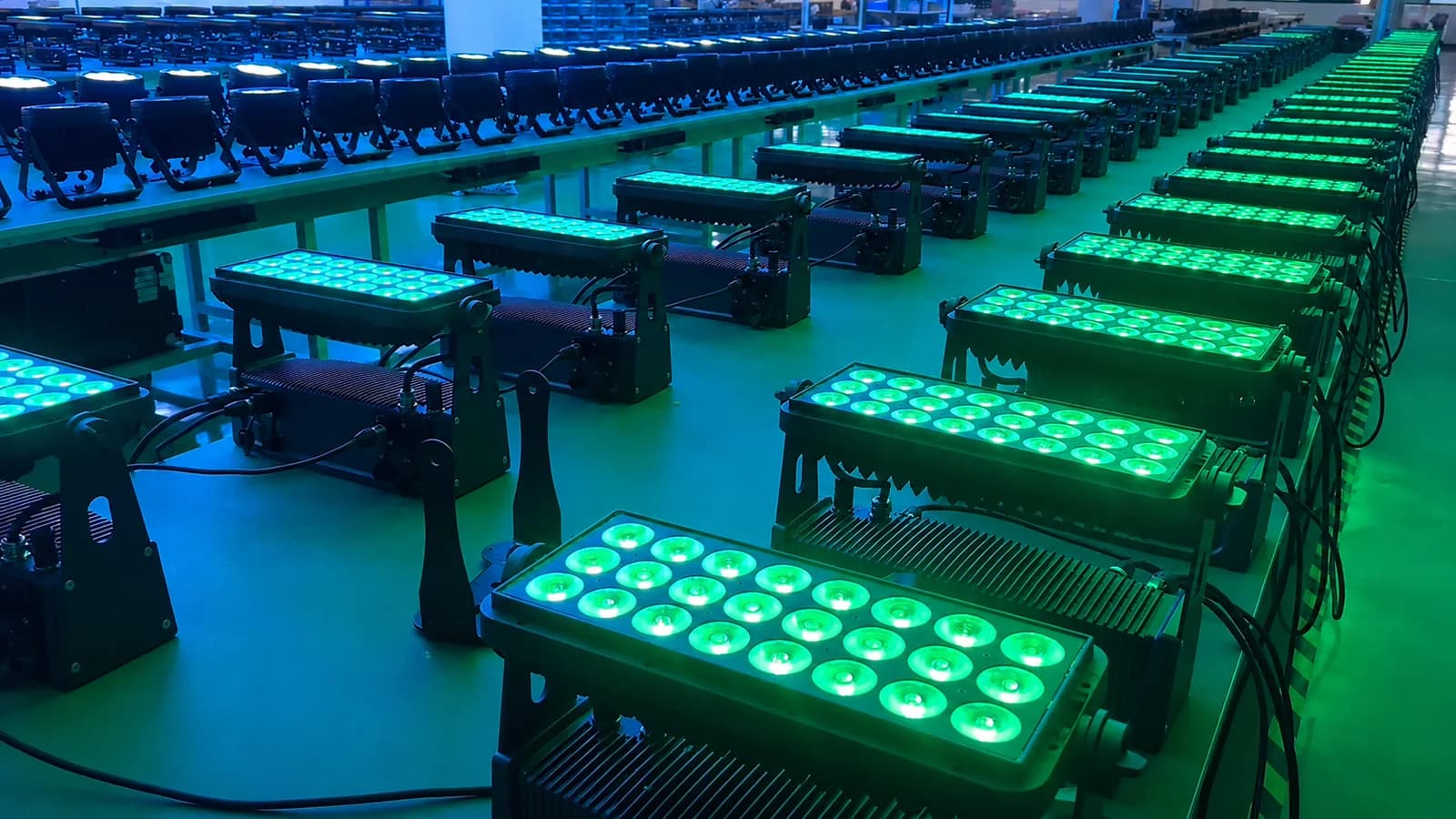 Rows of LumiUp battery lights producing blue-green saturated color during a factory test