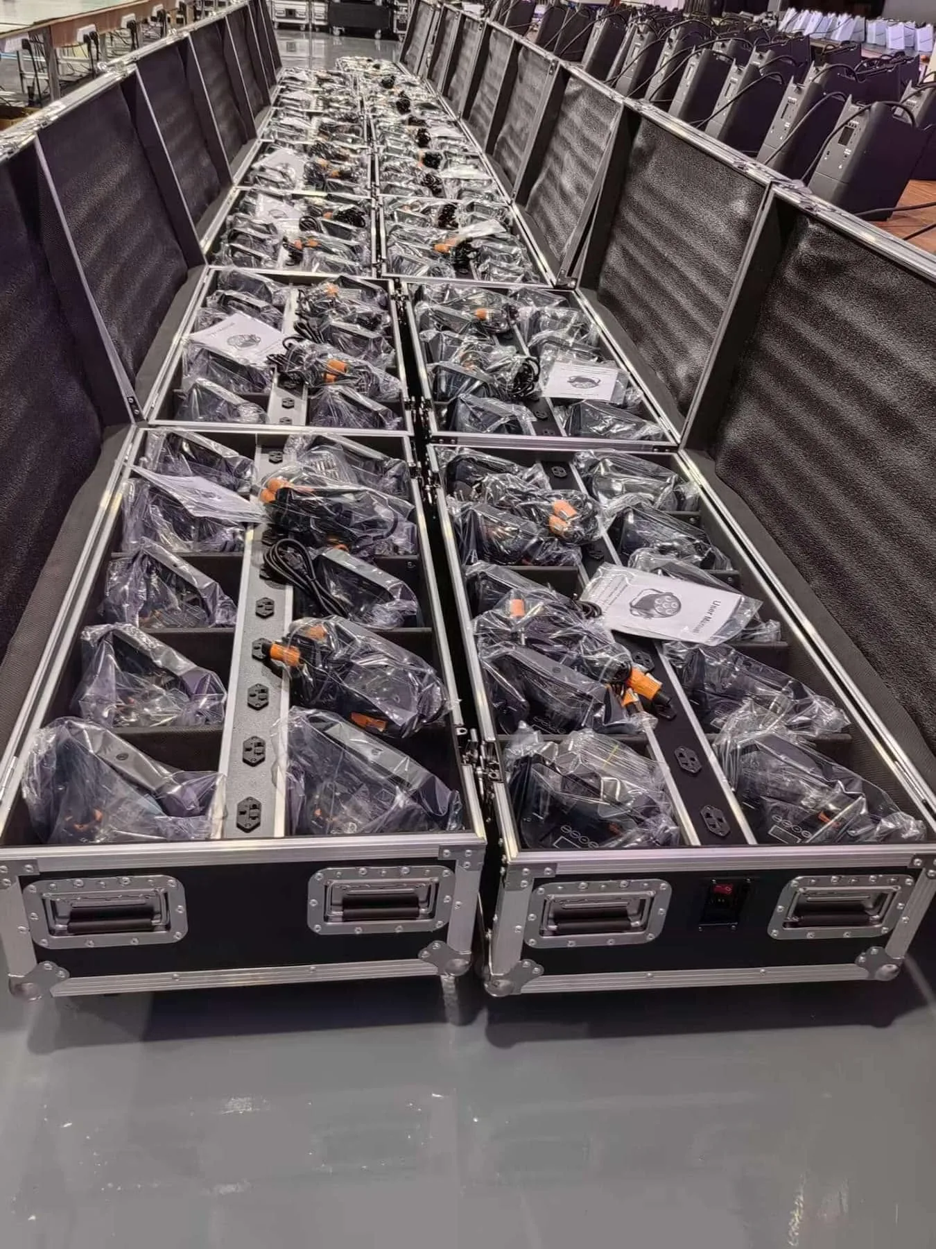 Open battery PAR flight cases with individually bagged fixtures, power cables, and printed manuals