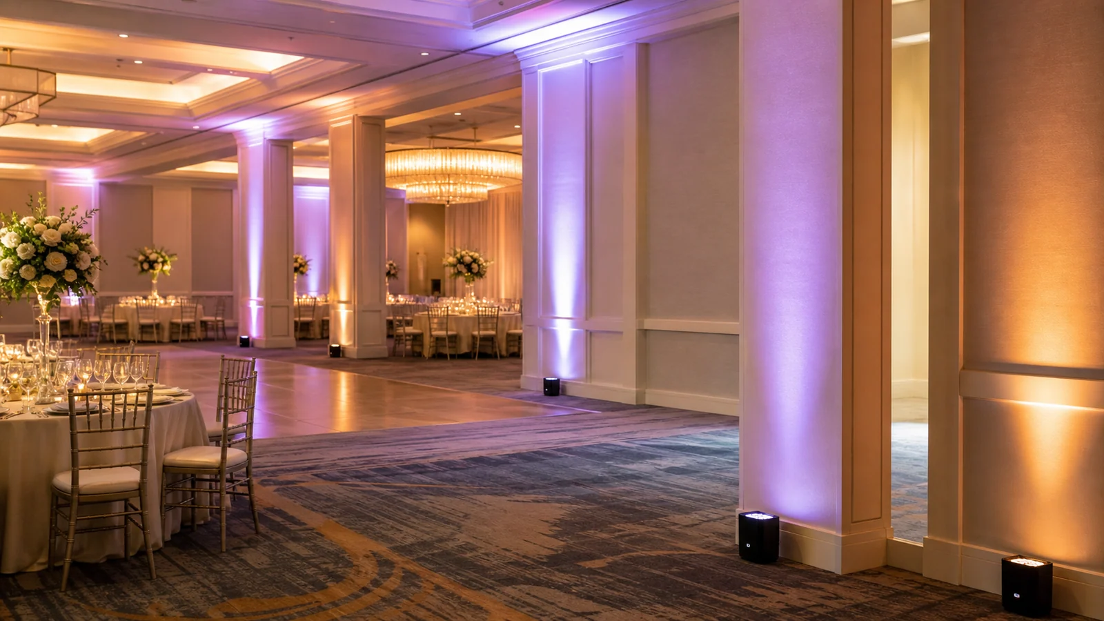 Battery powered uplights creating cable-free event lighting in an elegant ballroom