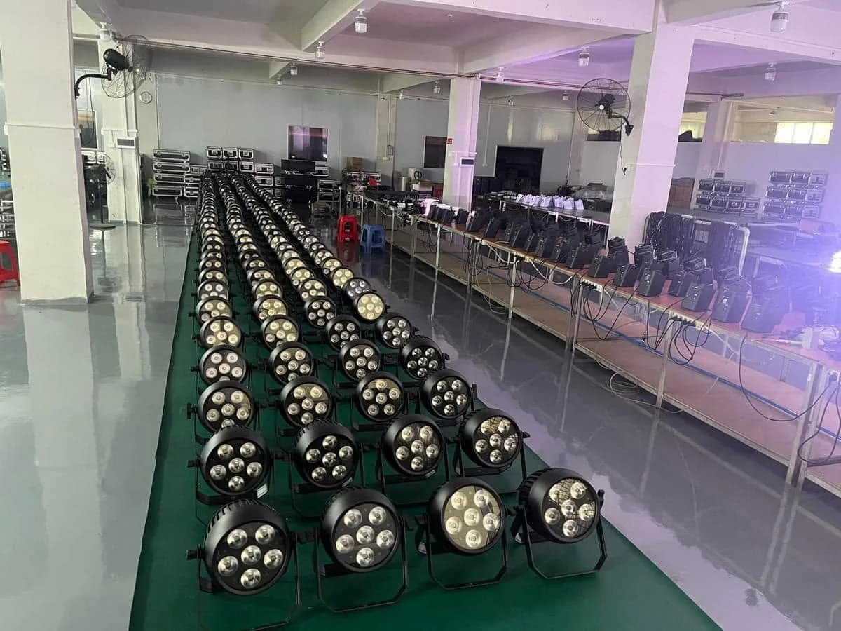 Rows of battery PAR fixtures and charging cases arranged for a factory batch check